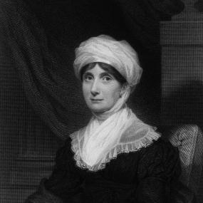 Engraving of Joanna Baillie, circa 1800, seated against a draped background. Her white headscarf contrasts with the dark
            background.