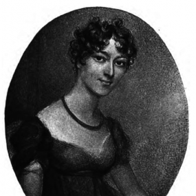 Photograph of a charcoal drawing of Baroness Barbarina Brand Dacre. The image is oval, showing her seated at a three-quarter turn, wearing a dark, high-waisted dress with a low neckline and puffed sleeves. She has short, dark, curly hair, and wears a single-strand necklace.