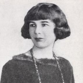 Black and white, half-length photo of Sheila Kaye-Smith from "Harper's Magazine, October 1922. She looks to her right, wearing a boat-neck dark top with a long beaded necklace; her wavy, dark hair is bobbed, with a fringe.