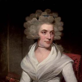 Photograph of a painting of Anna Margaretta Larpent by Sir Martin Archer Shee. Larpent is seated in a red upholstered chair, with stacked books in the background. She is wearing a gauzy white dress with a blue sash around the waist. She has a wide halo of curly hair with a blue band tied around it.