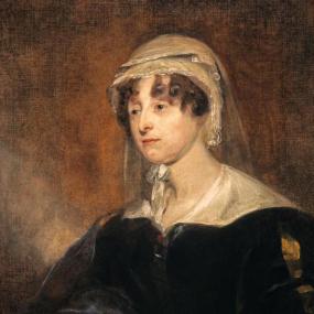 Photograph of a painting of Carolina Oliphant, Lady Nairne, by John Watson Gordon, c. 1818. She is shown from the waist up, wearing a black dress with a white collar, and yellow trim at the sleeves. Her dark curled hair is visible around her face; the rest is covered by a white cap with a sheer veil hanging behind. Scottish National Portrait Gallery.