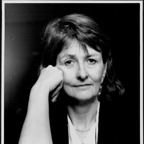 Black-and-white photo of Anne Oakley, 17 November 1992. She is seated with her left hand rested on her books, including The Secret Lives of
            Eleanor Jenkinson. 