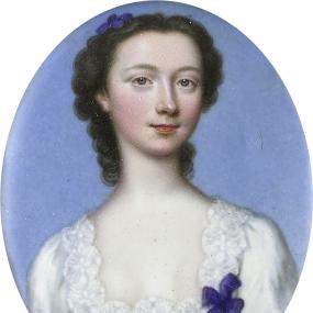 Colour photograph of an oval miniature of Catherine Talbot by Christian Friedrich Zincke. She is seen from the shoulders up, against a pale blue background. She is wearing a white bodice with a lace-trimmed square neckline, blue lacing, and two blue bows. Her curly dark hair is pulled loosely back and decorated with a blue bow or flower. On the back is inscribed "Catherine Talbot. / celebrated / for her genius and piety. / died unmarried. / 1770./ Zincke."