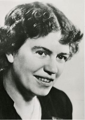 Black and white head-shot of Margaret Mead. She is wearing a dark jacket and she has dark, curly, jaw-length hair.
