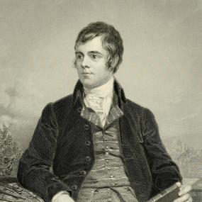 Engraving of Robert Burns, related to the painting by Alexander Nasmyth. This image extends to three-quarter length, showing Burns seated outdoors with a book in one hand and pencil in the other.