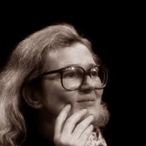 Black-and-white portrait photograph of Angela Carter, seated, at an event in Lecce, Italy, May
            1986.