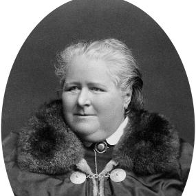 Black and white photograph of Frances Power Cobbe in middle age. She faces forward, but looks out slightly to her right. Her expression is resolute. Her grey hair is pulled away from her face, and she wears a coat with a large fur collar, under which is visible a shirt with a stiff white collar and a silver chain.
