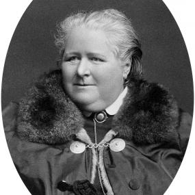 Black and white photograph of Frances Power Cobbe in middle age. She faces forward, but looks out slightly to her right. Her expression is resolute. Her grey hair is pulled away from her face, and she wears a coat with a large fur collar, under which is visible a shirt with a stiff white collar and a silver chain.