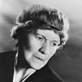 Black-and-white close-up photograph, circa 1957, of Ivy Compton-Burnett looking off-camera.