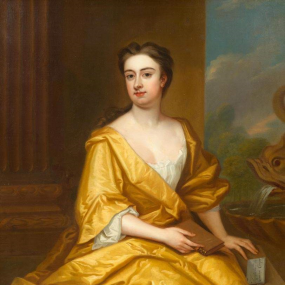 Portrait of Mary, Countess Cowper, by Godfrey Kneller or one of his school, 1709. She sits facing the viewer, head a little turned to her right, on a stone bench, by a fountain in front of a stone column and landscape. She wears a voluminous golden gown with white lace showing at the wrist and deep neckline, and holds a book in her right hand. A piece of paper with writing on it lies beside her.