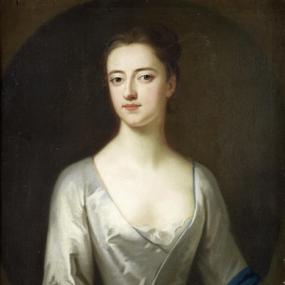 Photograph of a half-length painting probably of Sarah, Lady Cowper, by one of the circle of Enoch Seeman. She wears an ivory gown with a lace-filled décolleté, and a contrasting blue band at waist and sleeves. Her dark hair is piled on top of her head.