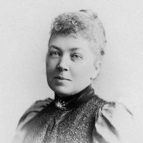 Black-and-white photograph portrait of B. M. Croker, wearing a blouse or dress with puff sleeves and a star brooch. 