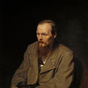 Painting of Fyodor Mikhailovich Dostoyevsky by Vasily Perov, 1872. Dostoyevsky is seated, wearing a brown greatcoat, looking down with hands clasped on his knees. Tretyakov Gallery, Moscow.