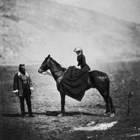 Black-and-white photo of Frances Isabella Duberly on a horse in front of her husaband Captain Henry Duberly during the Crimean War, 1855. 