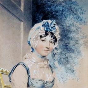 Watercolour portrait of youthful-looking Maria Edgeworth by John Downman, 1807. She sits on a straight-backed chair, wearing a lacy cap with a blue bow, and a blue, empire-style dress over white, high-necked, gauzy linen.