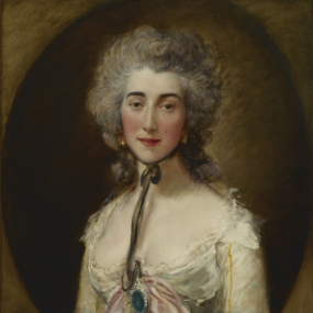 Portrait of Grace Elliott by Thomas Gainsborough, c. 1782. She faces the viewer with a neutral expression, wearing a low-necked, high-waisted white gown with a pink bow and blue brooch at the decolletage. Her hair is styled away from her face, frizzed and powdered, and a black ribbon tied under her chin and hangs to her bosom.