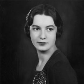 Black-and-white portrait photo of Pamela Frankau, 1928. The portrait is very minimal aside from a patterned scarf/brooch on the left side of
            her dress. 