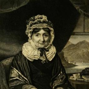 Black and white engraving of Anne Grant by H. Robinson after a painting by K. Macleay. She sits in an armchair wearing a large ribboned cap and frilled collar tied with a black bow, with a shawl over her dress. Behind her is a dark curtain and a small table with books and papers. Above her right shoulder a window shows a Highland scene: a little boat on a tree-fringed loch and hills or mountains  behind.