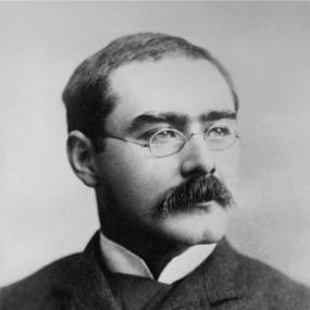 Black-and-white photograph of Rudyard Kipling by Elliott and Fry. He has metal-framed glasses and a thick moustache; he is looking to the right.