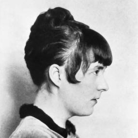 Black-and-white portrait photo of Katherine Mansfield. She is pictures in profile.