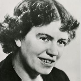 Black and white head-shot of Margaret Mead. She is wearing a dark jacket and she has dark, curly, jaw-length hair.