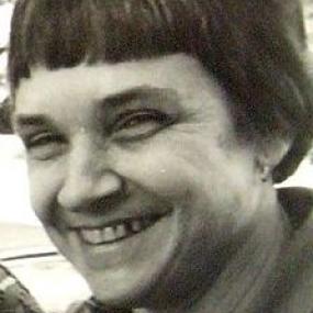 Black and white head-shot of Adrienne Rich. She has jaw-length hair with short bangs, and she wears a collared shirt.