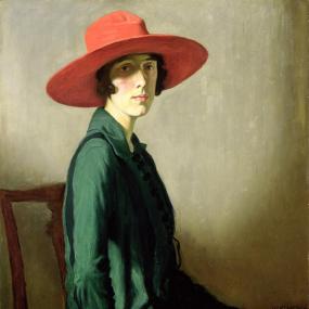 Three-quarter-length painting of Vita Sackville-West by William Strang, 1918. She is shown from the side but turning her face to the viewer, seated, against a plain wall. She is wearing a yellow skirt, a flowing green jacket, and most strikingly a broad-brimmed red hat over short dark hair. One hand holds a book. Kelvingrove Art Gallery.