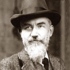 Sepia head-and-shoulders photograph of George Bernard Shaw by Bains News Service, 8 November 1909. He is seen full-face, with a neat beard, gazing a little to the right with a faint smile. He wears a wool jacket and waistcoat with thin stripes, and a bowler hat slightly tilted.