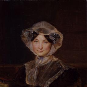 Photograph of a painting of Frances Trollope by Auguste Hervieu, c. 1832, seated in a red upholstered chair, against a dark background. She is wearing a dark red-brown dress with blue and gold cuffs, a blue and gold buckle on the waistband, and large lace collar matching the bonnet that covers her dark, smooth, middle-parted hair. National Portrait Gallery.
