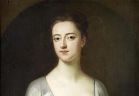 Photograph of a half-length painting probably of Sarah, Lady Cowper, by one of the circle of Enoch Seeman. She wears an ivory gown with a lace-filled décolleté, and a contrasting blue band at waist and sleeves. Her dark hair is piled on top of her head.